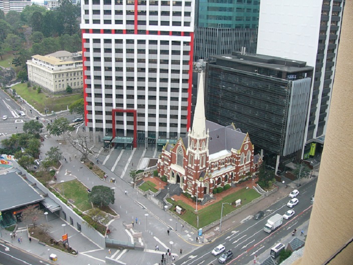 The Albert Street Uniting Church dwarfed by modern skyscrapers in the Brisbane City Centre.