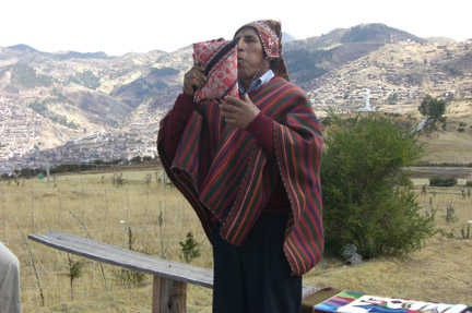 Enrique, the local cuandero (native folk healer)performing a healing ceremony. Cusco in the background.